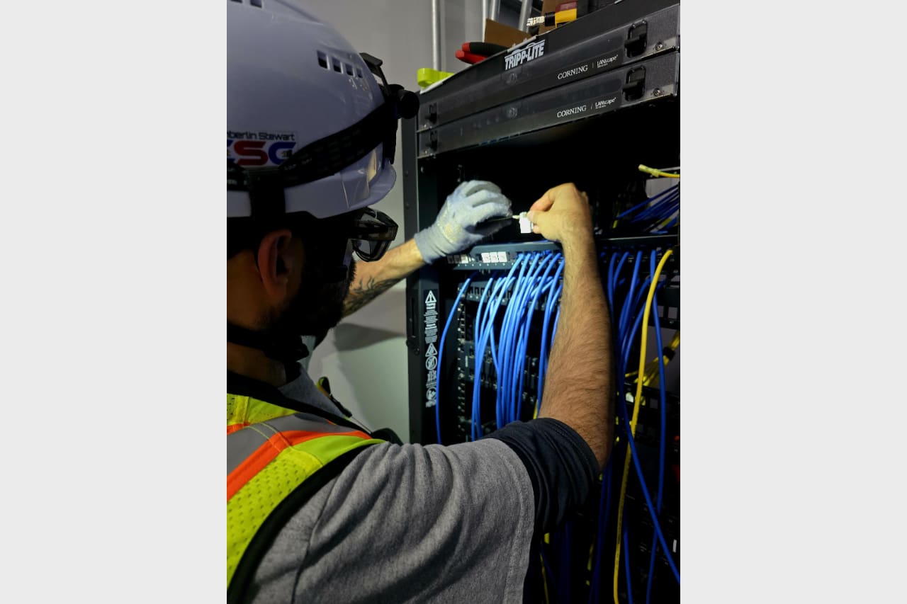 Technician organizing network cables in a server rack.